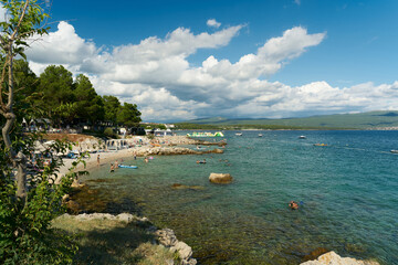 Holidaymakers bathing in a bay at a campsite near the old town of Krk in Croatia