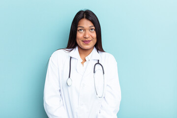 Young doctor Venezuelan woman isolated on blue background dreaming of achieving goals and purposes