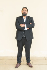 Full length portrait of handsome bearded Indian businessman against plain background - 463380963