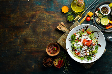 Vegetable salad: lettuce, tomatoes, cucumber and cream sauce. Caesar. Top view. Top view. Rustic style.