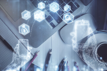 Technology hologram drawing over computer on the desktop background. Top view. Double exposure. Tech concept.