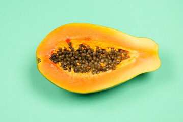 Papaya fruit on a green background in woman hands. Tropical fruit. Half papaya.