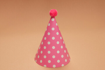 Colorful birthday cap on brown  background.
