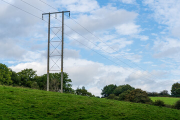 Fototapeta na wymiar overhead high voltage cables and natural wooden pylon providing power to a rural environment