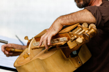 A man plays an old musical mechanical string instrument hurdy-gurdy