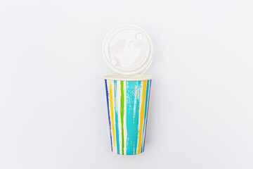 Take away colored paper coffee cup with plastic cap on light Bright colors and summer drink concept.