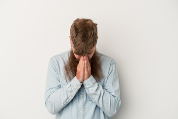 Young caucasian ginger man with long beard isolated on white background praying, showing devotion, religious person looking for divine inspiration.