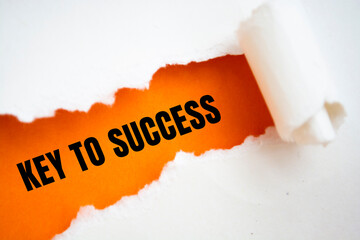 Text appearing behind torn white envelop - Key to success
