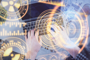 Double exposure of man's hands typing over computer keyboard and tech theme hologram drawing. Top view. Technology concept.