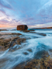 Beautiful sunrise at North Bondi rocks with high tide.