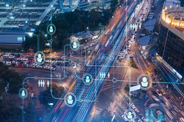 Hologram glowing social media icons over night busy road traffic in Bangkok, Southeast Asia. The concept of networking and establishing new connections between people in businesses. Double exposure