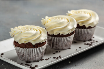 chocolate cupcakes with cream cheese frosting on a rack, delicious dessert
