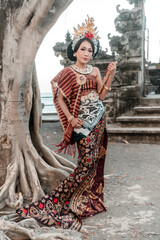 Fototapeta na wymiar Balinese woman in traditional costume and hand fan, indonesian girl, hindu temple background, Bali.