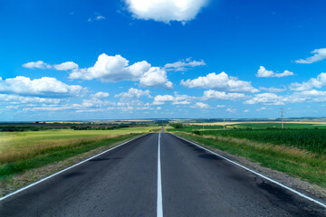 Russian rural highway stretching into the distance. Russian fields and simplicity. Daytime shooting. The clouds.