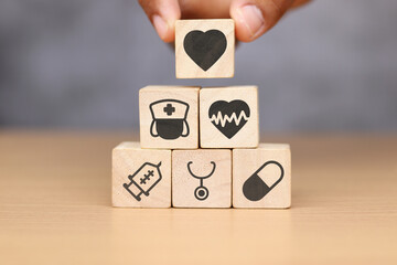 Medical symbols on wooden cubes arranged on wooden table, medical and pharmaceutical concepts. 