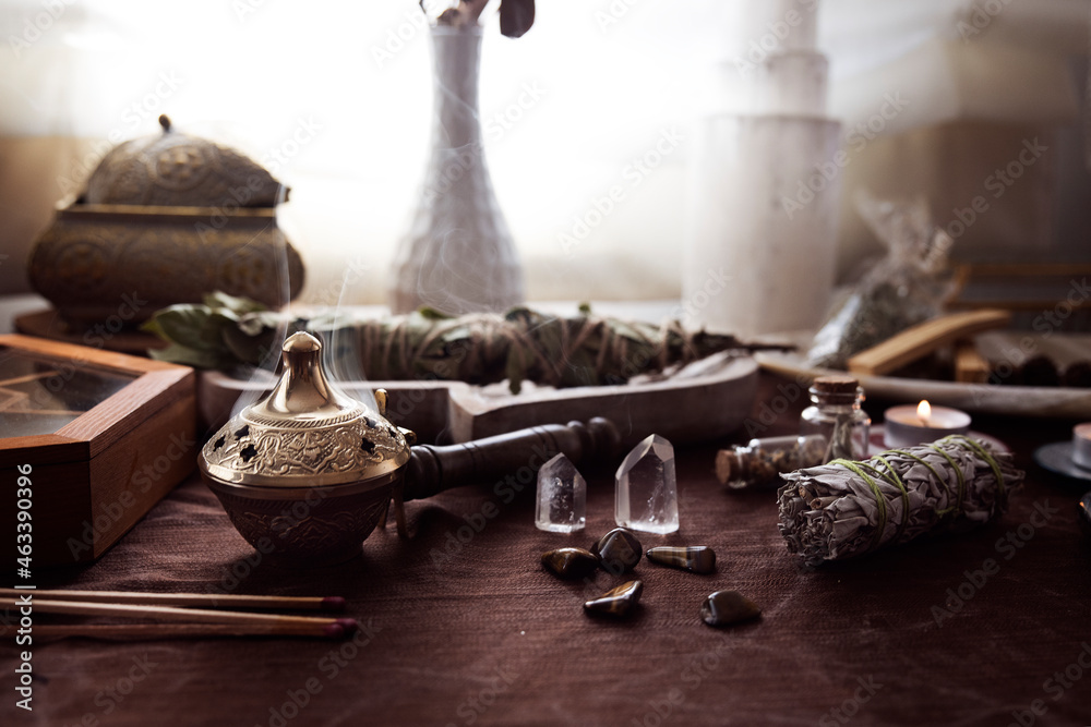 Wall mural altar for energetic cleansing and witch rituals with various bundles, stones and crystals and a medi