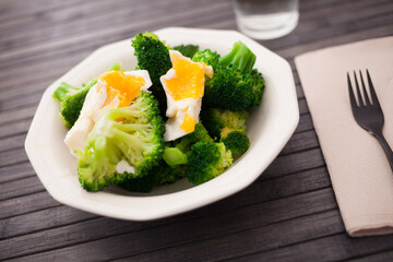 diet food. steamed broccoli with boiled egg on plate