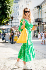 Young beautyful woman with yellow linen eco bag on city background.