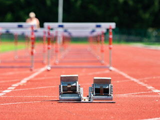 Obstacle course training. Athletics Starting Blocks and red running tracks
