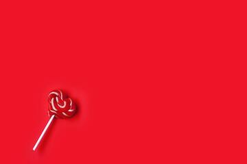 valentine day, striped lollipop shape heart on stick, on red paper background