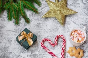 New Year's or Christmas composition of spruce green branches, New Year's star, gift cup with marshmallows and lollipops