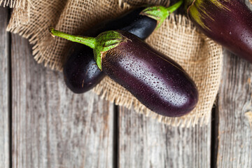 Raw purple eggplant. Fresh aubergine on wooden background. Top view