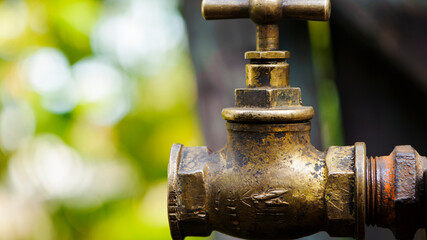 old brass water tap isolated on a light background. tap valve. old copper retro faucet on a rusty pipe. plumbing, repair, dismantling. Vintage close-up. outdoor water tap