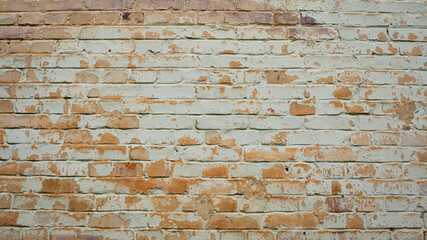 brick wall facade texture texture background. A textured background of decayed old red and white bricks in an exterior uneven wall of a house with dirty whitewashed worn plaster. Brick wall
