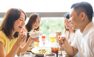 Happy Young group enjoying food and drink in restaurant