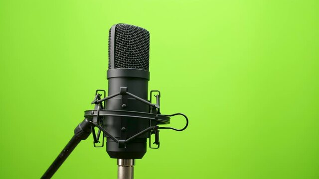 black Studio condenser microphone isolated on green screen background, Studio microphone, sound media, recording, camera orbit view 