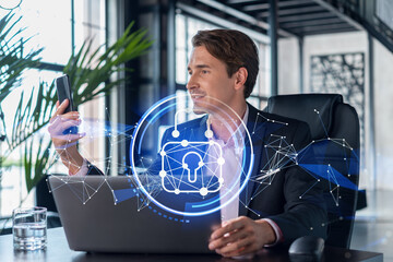 Businessman in suit checking cyber security using smart phone to protect clients confidential information. IT hologram lock icons over modern panoramic office background.