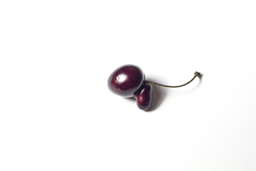 Ugly cherry on a white background close-up. Ugly fruit concept. Funny food. Spoiled food.