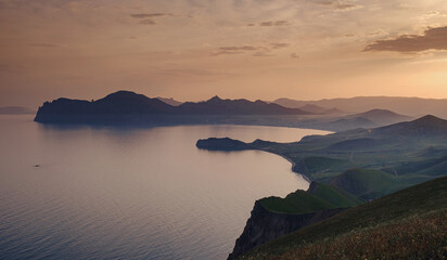 Beautiful sunset with rays over the contours of mountains with stones and sea. viewpoint between...