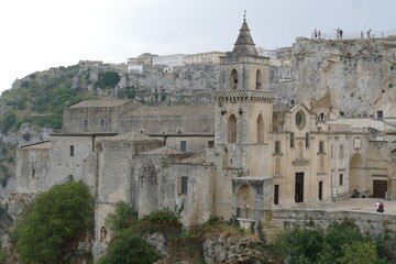 San Pietro Caveoso church in Matera placed on the precipice of the canyon carved by the Gravina River and on its right the arch that introduces in Sasso Caveoso