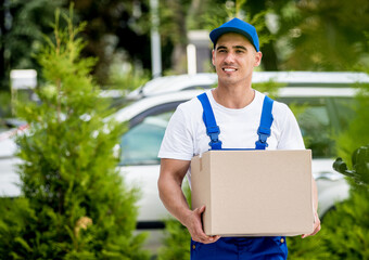 Young delivery man hold a cardboard box in his hands