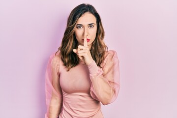 Obraz premium Young hispanic girl wearing casual clothes asking to be quiet with finger on lips. silence and secret concept.