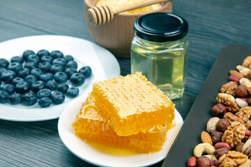 fresh assorted honey and blueberries on a wooden background. healthy organic vitamin food.