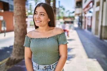 Young hispanic girl smiling happy standing at the city.