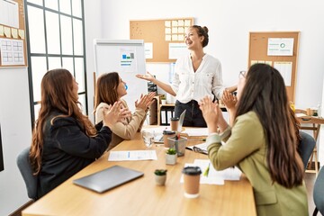 Group of young businesswomen smiling and clapping to partner at the office.