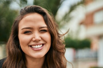 Young hispanic woman smiling happy standing at the city.