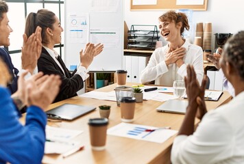 Group of business workers smiling and clapping to partner at the office.