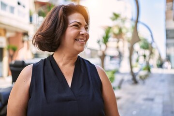 Middle age hispanic woman smiling happy and confident outdoors on a sunny day