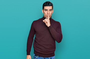 Fototapeta premium Handsome hispanic man wearing casual turtleneck sweater asking to be quiet with finger on lips. silence and secret concept.