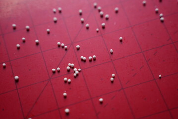 A lot of white tapioca pearl grains on top of a red background 