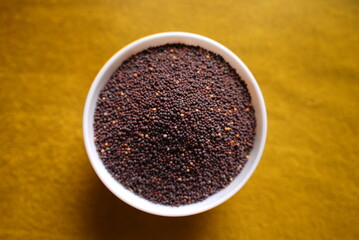 Some lentil grains on a ceramic bowl on top of red background