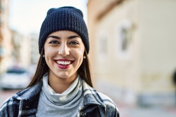 Young hispanic woman smiling happy standing at the city.