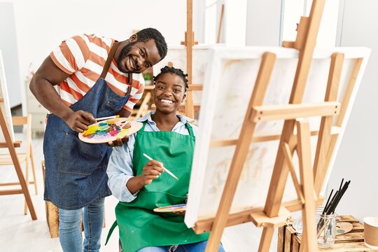 African american painter couple smiling happy painting at art studio.