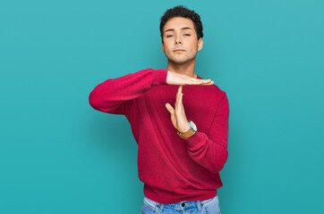 Young handsome man wearing casual clothes doing time out gesture with hands, frustrated and serious...