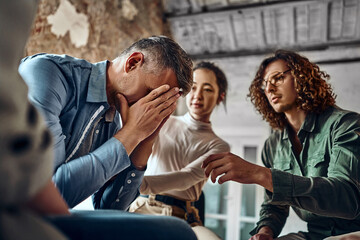 Young despair man crying during group therapy.