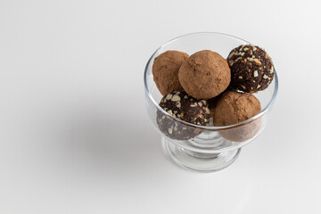 Chocolate date balls on a light background. Healthy vegan dessert. Copy space.